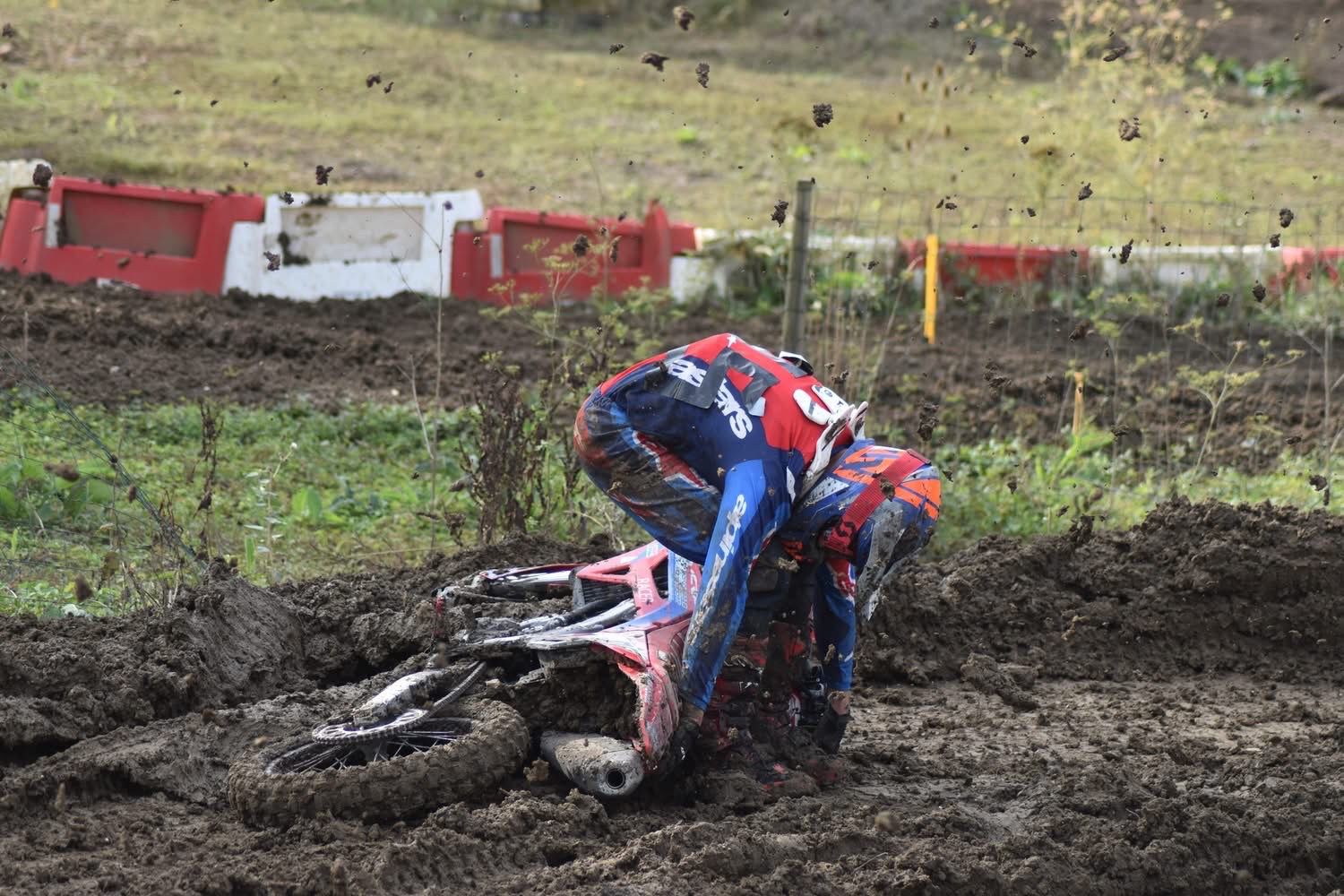 Baptiste au sol à côté de sa moto couchée dans la boue