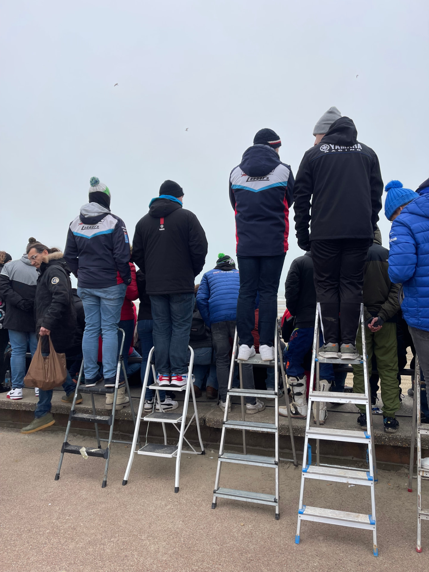 Le public monte sur des escabeaux pour voir passer la course.